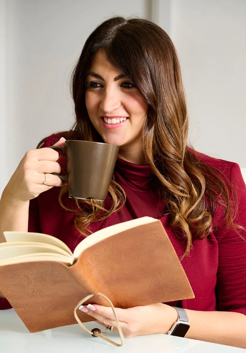 Maria Rosa Bianco sorride con una tazza e un libro aperto